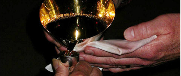 Hands pouring communion wine at Our Savior's Church